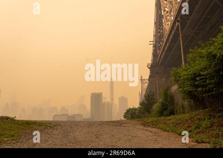 New York, Stati Uniti. 07th giugno, 2023. NEW YORK, NEW YORK - GIUGNO 07: A metà pomeriggio, il fumo proveniente dagli incendi boschivi canadesi copre il Queensboro Bridge (ufficialmente chiamato ed Koch Queensboro Bridge, e conosciuto anche come 59 Street Bridge) visto da Long Island City il 7 giugno 2023 nel Queens borough di New York City. Martedì sera New York è stata in cima alla lista delle principali città più inquinate del mondo, poiché il fumo degli incendi continua a coprire la costa orientale. La città ha emesso un parere sulla qualità dell'aria, che invita tutti i cittadini a rimanere al chiuso. Credit: Ron Adar/Alamy Live News Foto Stock