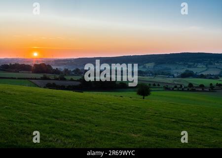 Una mattina presto con un cielo pieno di bei colori durante l'alba nel paesaggio collinare del Limburgo con viste spettacolari sul tipico Foto Stock