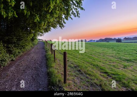 Una mattina presto con un cielo pieno di bei colori durante l'alba nel paesaggio collinare del Limburgo con viste spettacolari sul tipico Foto Stock