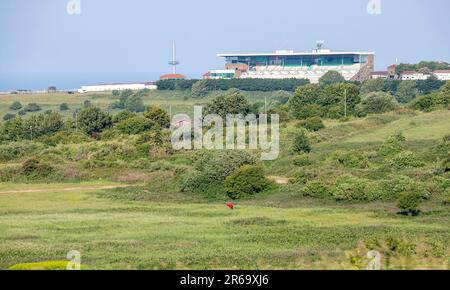 Brighton UK 8th Giugno 2023 - un camminatore di mattina presto gode il sole sotto l'ippodromo di Brighton come il tempo caldo è previsto per i prossimi giorni in tutta la Gran Bretagna : Credit Simon Dack / Alamy Live News Foto Stock