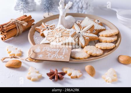 Biscotti di Natale fatti in casa con ornamenti in bianco Foto Stock