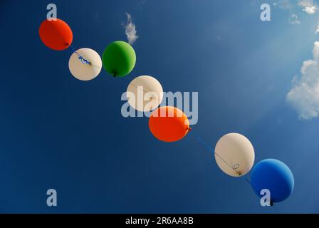 Un angolo basso di palloncini colorati su un filo contro un cielo blu Foto Stock