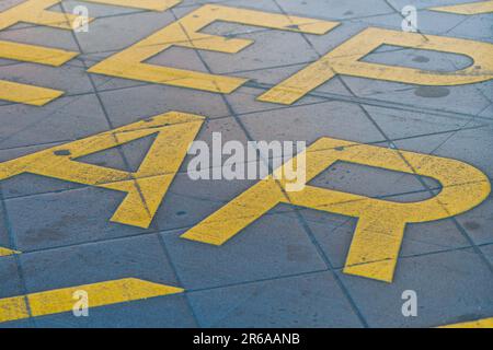 Tenere il cartello trasparente con le lettere grafiche gialle sul fondo stradale, Melbourne Australia. Foto Stock