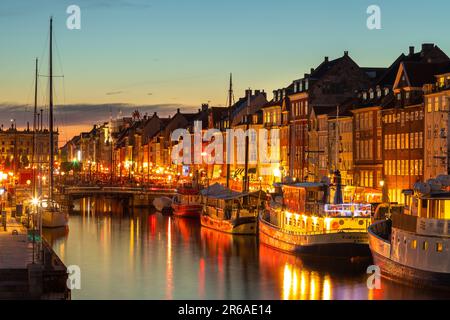 Danimarca, Copenaghen - 15 maggio 2019: Nyhavn di notte. Un lungomare del 17th ° secolo, il canale e il quartiere dei divertimenti con case di città dai colori vivaci, bar Foto Stock