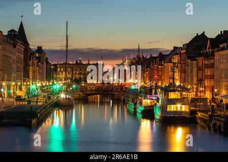 Danimarca, Copenaghen - 15 maggio 2019: Nyhavn di notte. Un lungomare del 17th ° secolo, il canale e il quartiere dei divertimenti con case di città dai colori vivaci, bar Foto Stock