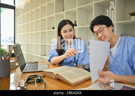 Studente medico che si prepara agli esami universitari, discutere la diagnosi del paziente in biblioteca. Concetto di stage medico Foto Stock