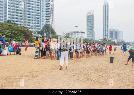 Un gruppo di turisti asiatici che si godono una giornata di relax su una spiaggia tropicale Foto Stock