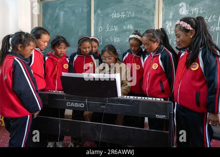 (230608) -- TINGRI, 8 giugno 2023 (Xinhua) -- l'insegnante di piano Basang (C) istruisce gli studenti di una scuola elementare della cittadina di Zhaxizom nella contea di Tingri, Xigaze City, regione autonoma del Tibet nel sud-ovest della Cina, 5 giugno 2023. La scuola elementare di Zhaxizom Township è la scuola più vicina al Monte Qomolangma, con una distanza di poco più di 40 chilometri. Per soddisfare le diverse esigenze degli studenti, la scuola ha istituito classi di interesse come pianoforte, informatica, arte, trasmissione, sport, danza e artigianato. Attualmente, la scuola elementare ha un solo pianoforte. Quindi, il KE elettronico Foto Stock