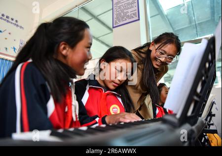 (230608) -- TINGRI, 8 giugno 2023 (Xinhua) -- l'insegnante di pianoforte Basang (R) istruisce gli studenti presso una scuola elementare della cittadina di Zhaxizom nella contea di Tingri, Xigaze City, regione autonoma del Tibet nel sud-ovest della Cina, 5 giugno 2023. La scuola elementare di Zhaxizom Township è la scuola più vicina al Monte Qomolangma, con una distanza di poco più di 40 chilometri. Per soddisfare le diverse esigenze degli studenti, la scuola ha istituito classi di interesse come pianoforte, informatica, arte, trasmissione, sport, danza e artigianato. Attualmente, la scuola elementare ha un solo pianoforte. Quindi, il KE elettronico Foto Stock