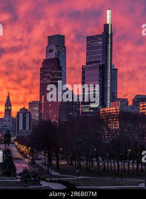 Questa immagine mostra uno splendido e sereno skyline contro un vibrante cielo del tramonto rosa e viola Foto Stock