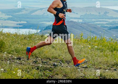 gara di maratona di corsa di corridore maschile in background di montagne e lago, ultramaratona estiva Foto Stock
