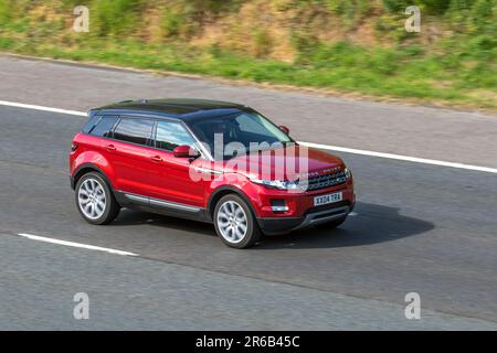 2014 Red Land Rover Range Rover Evoque Pure T; viaggia a velocità sostenuta sull'autostrada M6 a Greater Manchester, Regno Unito Foto Stock