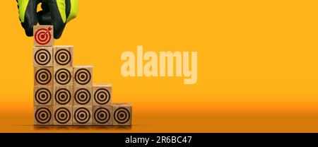 Guanti disposti a mano con blocchi di legno con molti bersagli marroni vuoti e uno rosso con una freccia che raggiunge il centro, su sfondo arancione. Foto Stock