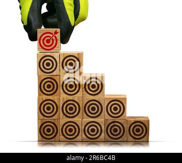 Mano con guanti disponendo blocchi di legno con molti bersagli marroni vuoti e uno rosso con una freccia che raggiunge il centro, isolato su sfondo bianco. Foto Stock