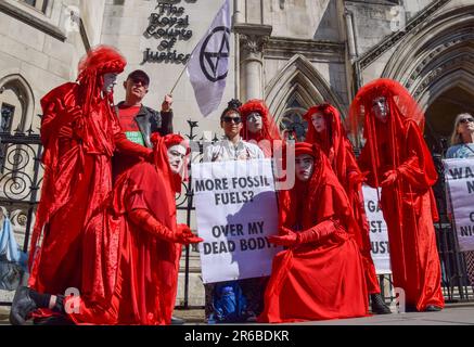 Durante la manifestazione si esibiscono i manifestanti della ribellione che indossano costumi rossi, noti come la Brigata del ribelle Rosso. I manifestanti del clima si sono riuniti al di fuori della Royal Courts of Justice durante la revisione giudiziaria del permesso di pianificazione per il petrolio e il gas del Regno Unito per esplorare per i combustibili fossili vicino al villaggio di Dunsfold. (Foto di Vuk Valcic / SOPA Images/Sipa USA) Foto Stock