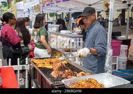 Washington, DC - Un uomo grigliate calamari presso uno stand gastronomico al Fiesta Asia Street Fair. Il festival annuale offre intrattenimento e cibo da più di Foto Stock