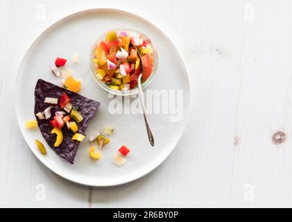 Un croccante tortilla di mais blu sormontato da salsa casereccia. Foto Stock