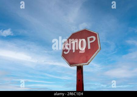 Segnale di stop ottagonale rosso su sfondo cielo blu. Foto Stock