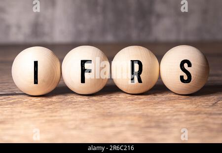 Concetto aziendale. Sulla tavola con i documenti sono presenti dei cubi di legno con l'iscrizione - IFRS. Foto Stock