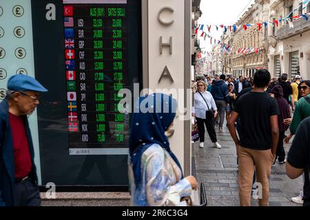 Istanbul, Turchia. 08th giugno, 2023. Le persone passano davanti allo schermo a LED che mostra i tassi di valuta correnti. Dopo le elezioni del 28 maggio, la Banca centrale della Repubblica di Turchia ha smesso di sopprimere il tasso dollaro/TL emettendo valuta estera al mercato attraverso le banche pubbliche, e il tasso del dollaro, che era di 19,52 lire il 28 maggio, è diventato di 23,36 lire a partire dal giugno 8. (Foto di Tunahan Turhan/SOPA Images/Sipa USA) Credit: Sipa USA/Alamy Live News Foto Stock