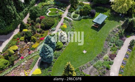 Veduta aerea del giardino botanico con aiuole e alberi topiari (abete rosso e pino) a Breslavia e panchina su prato a forma di cuore Foto Stock