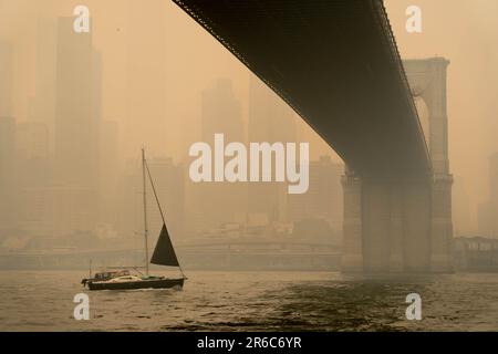 Brooklyn, New York, Stati Uniti. 8th giugno, 2023. Il Ponte Broklyn, come un fosso di fumo, ha avvolto NYC il Mercoledì, originando da incendi canadesi che hanno soffiato verso sud. I livelli di qualità dell'aria hanno raggiunto un record a NYC con numeri che raggiungono i 342 sull'AQI. I funzionari di New York hanno consigliato ai residenti di rimanere al chiuso, limitare l'esposizione all'aperto e indossare maschere all'aperto. Alle popolazioni vulnerabili, come i bambini e gli adulti più grandi, è stato detto di evitare di andare all'esterno. Foto Stock