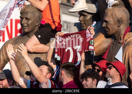 Newham, Londra, Regno Unito. 8th Giu, 2023. I giocatori e lo staff del West Ham United Football Club hanno festeggiato la vittoria del trofeo UEFA Europa Conference League con una parata di vittoria in autobus aperto attraverso il quartiere, dalla statua dei campioni vicino al vecchio stadio Boleyn Ground della squadra e terminando al Municipio di Stratford. La Statua rende omaggio agli ex giocatori della storia del club, anche dall’era della precedente vittoria della Coppa UEFA del 1965. I tifosi hanno tracciato la strada per festeggiare e rallegrarsi con la loro squadra. Champions replica camicia di tifosi da Champions statue Foto Stock