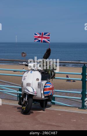 Scooter d'epoca sul lungomare della baia di Whitley Foto Stock