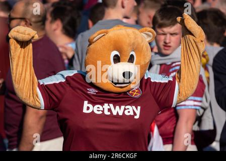 Newham, Londra, Regno Unito. 8th Giu, 2023. I giocatori e lo staff del West Ham United Football Club hanno festeggiato la vittoria del trofeo UEFA Europa Conference League con una parata di vittoria in autobus aperto attraverso il quartiere, dalla statua dei campioni vicino al vecchio stadio Boleyn Ground della squadra e terminando al Municipio di Stratford. La Statua rende omaggio agli ex giocatori della storia del club, anche dall’era della precedente vittoria della Coppa UEFA del 1965. I tifosi hanno tracciato la strada per festeggiare e rallegrarsi con la loro squadra. Ventilatore in costume da orso Foto Stock