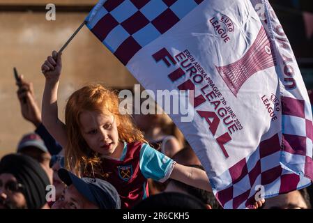 Newham, Londra, Regno Unito. 8th Giu, 2023. I giocatori e lo staff del West Ham United Football Club hanno festeggiato la vittoria del trofeo UEFA Europa Conference League con una parata di vittoria in autobus aperto attraverso il quartiere, dalla statua dei campioni vicino al vecchio stadio Boleyn Ground della squadra e terminando al Municipio di Stratford. I tifosi hanno tracciato la strada per festeggiare e rallegrarsi con la loro squadra. Giovane ragazza con bandiera che celebra Foto Stock