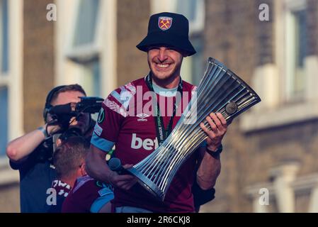 Newham, Londra, Regno Unito. 8th Giu, 2023. I giocatori e lo staff del West Ham United Football Club hanno festeggiato la vittoria del trofeo UEFA Europa Conference League con una parata di vittoria in autobus scoperto attraverso il quartiere, dalla statua dei campioni vicino al vecchio stadio Boleyn Ground della squadra. Capitano del club Declan Rice con il trofeo dei vincitori Foto Stock