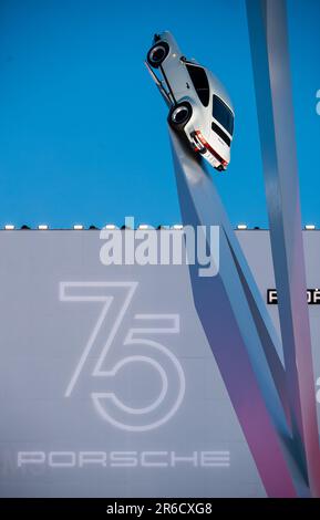 Stoccarda, Germania. 08th giugno, 2023. Una Porsche 911 di vecchia generazione è appesa davanti a un'illustrazione di '75 anni di Porsche' al Porsche Museum. Credit: Christoph Schmidt/dpa/Alamy Live News Foto Stock