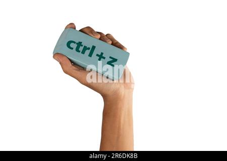 Mano maschio nera che tiene una gomma con iscrizione ctrl z su sfondo bianco Foto Stock