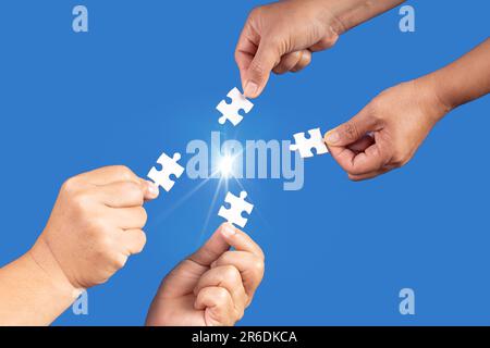 Mani che tengono jigsaw puzzle pezzo con sfondo blu chiaro, business di successo, strategia di soluzione, concetto di partnership lavoro di squadra Foto Stock