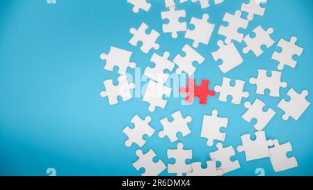 Pezzi di puzzle jigsaw bianco incompiuto su sfondo blu, l'ultimo pezzo di puzzle jigsaw, Copia spazio. Foto Stock