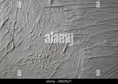 Fondo a rilievo grigio fluido, sfondo in gesso ondulato, sfondo astratto con pennellate Foto Stock