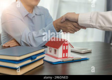 Agente immobiliare che scuote le mani con il cliente dopo la firma del contratto e fatto affari per il diritto di trasferimento della proprietà. Uomo intermediario immobiliare Foto Stock