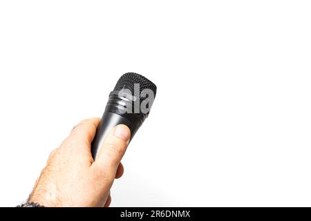 mano maschile che tiene un microfono nero, isolato su sfondo bianco Foto Stock