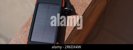 Banca di energia solare per caricare il telefono cellulare che si trova sotto i raggi di sole primo piano Foto Stock