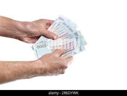 Mano degli uomini che tiene la valuta ucraina isolato su sfondo bianco. Un sacco di 1000 banconote di hryvnia Foto Stock