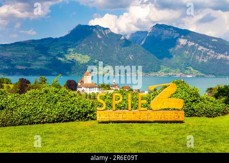 Vista sul lago di Thun, il castello di Spiez e Merligen in lontananza, Spiez, Svizzera Foto Stock