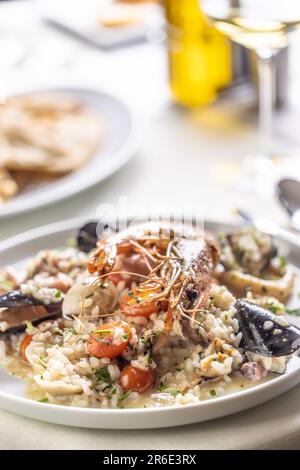 Particolare di un risotto di pesce fatto la maniera italiana e servito su un piatto poco profondo. Foto Stock