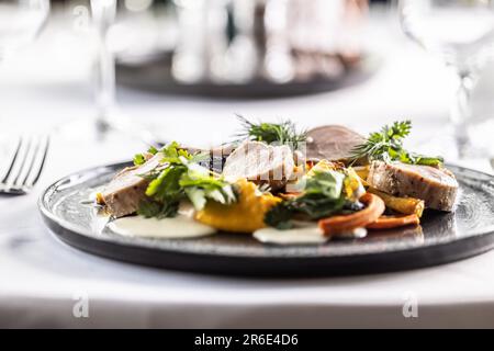 Maiale e carote al forno con purea di carote e foglie di coriandolo. Foto Stock