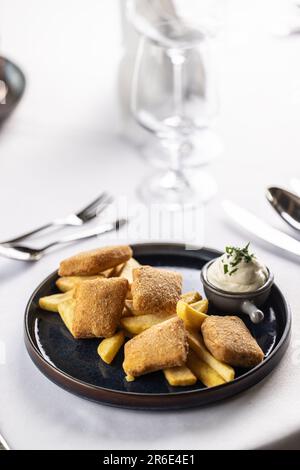 Formaggio fritto impanato con patatine e maionese. Foto Stock