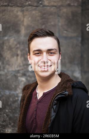 Ritratto di un giovane sorridente con un'acconciatura elegante Foto Stock