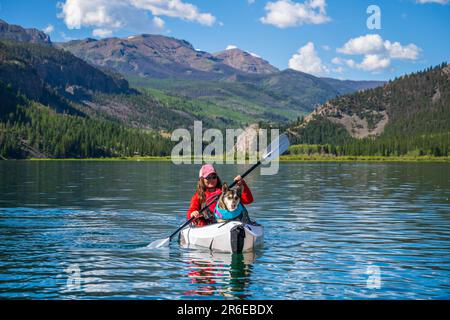 Kayak da bambine e cani sul lago Colorado Mountain Foto Stock
