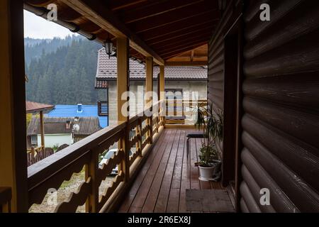 Bella sala terrazza moderna, una grande terrazza in legno in una casa di legno con una foresta intorno. Natura e concetto di vacanza. Foto Stock