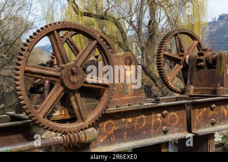 vecchio meccanismo meccanico di ingranaggi di metallo sulla diga abbandonata. Foto Stock