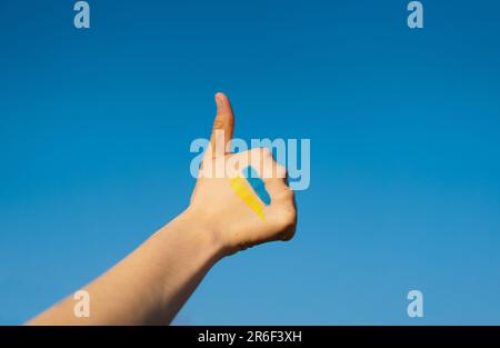 Ragazza Ucraina che mostra un segno di pollice su segno. Foto Stock