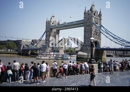 Persone che si godono il caldo tempo vicino Tower Bridge a Londra. Data immagine: Venerdì 9 giugno 2023. Foto Stock